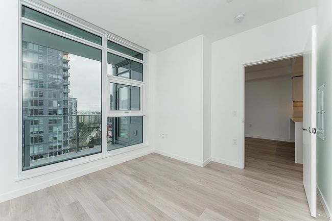 Spare room featuring baseboards, wood finished floors, and a wall of windows | Image 16