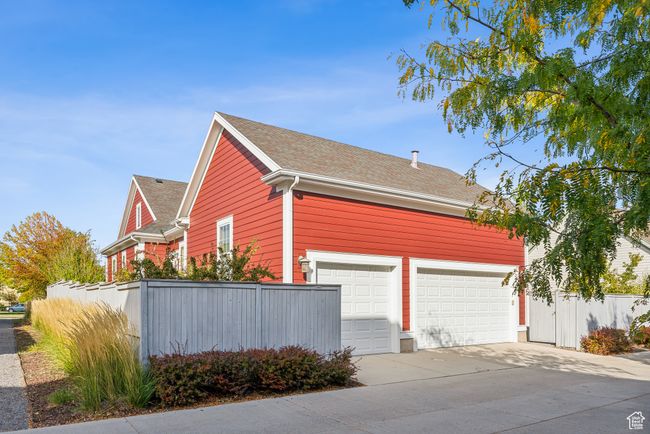View of side of home featuring driveway, fence, and roof with shingles | Image 41