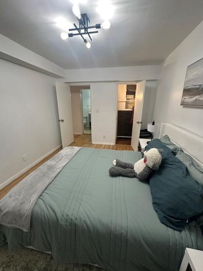 Bedroom with baseboards, wood finished floors, a walk in closet, and a closet | Image 7