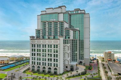 View of building exterior featuring a view of the beach and a water view | Image 1