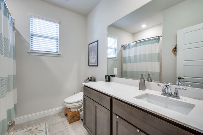Full bath with tile patterned flooring, vanity, toilet, baseboards, and curtained shower | Image 19