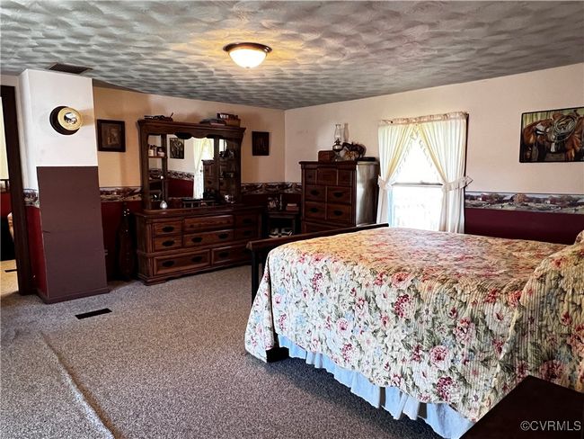 Bedroom with a textured ceiling and carpet floors | Image 25