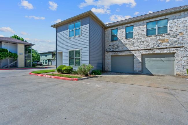 View of property with stone siding, driveway, and a garage | Image 27