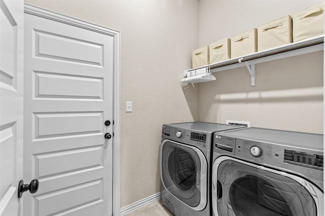 Laundry area with washing machine and clothes dryer and light tile patterned flooring | Image 27