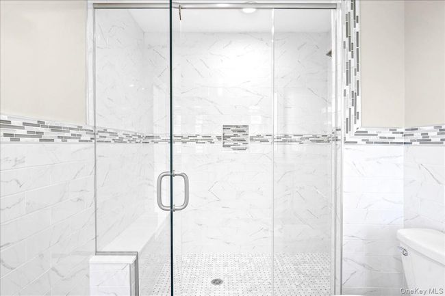 Full bathroom with toilet, a shower stall, and tile walls | Image 25