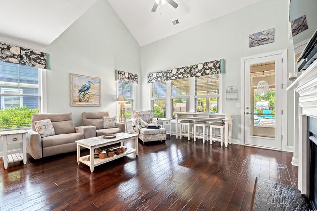 Living room with high vaulted ceiling, hardwood / wood-style flooring, ceiling fan, and a fireplace with flush hearth | Image 16