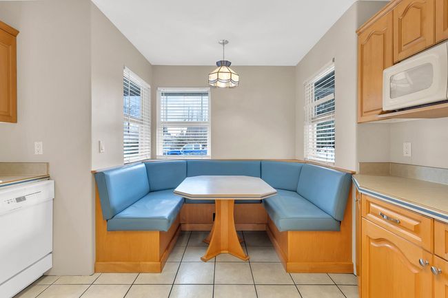 Living area with breakfast area and light tile patterned floors | Image 8