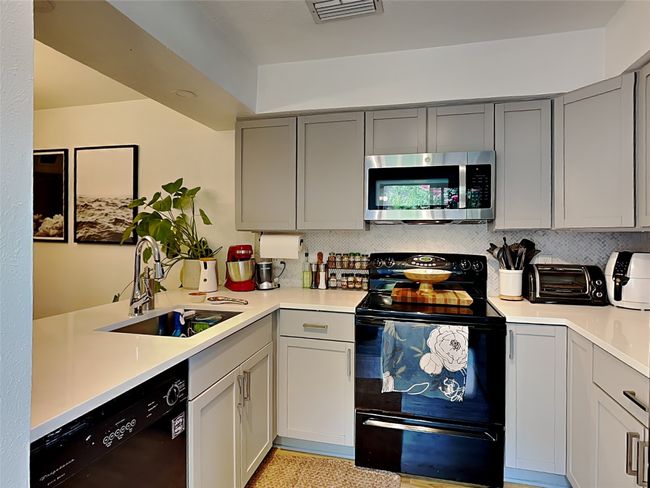 Kitchen featuring black appliances, gray cabinetry, and light countertops | Image 4