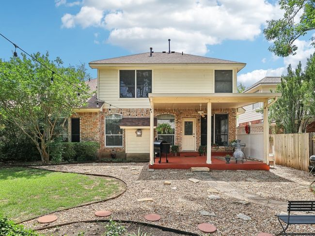 Rear view of house with fence, brick siding, and covered porch | Image 32