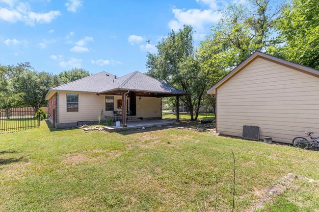 Rear view of house featuring a patio area and a shingled roof | Image 24