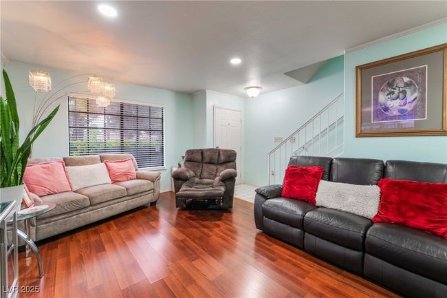 Living room featuring stairway, wood finished floors, an inviting chandelier, and recessed lighting | Image 8