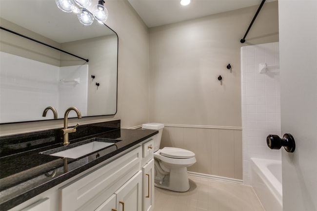 Full bathroom with vanity, shower / washtub combination, a wainscoted wall, and tile patterned floors | Image 29