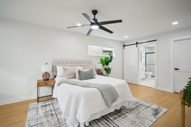 Bedroom with recessed lighting, a barn door, and light wood finished floors | Image 14