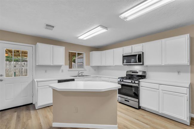 Rows of cabinets and countertops space in the lovely kitchen. | Image 11