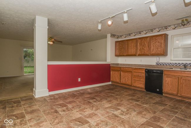 kitchen with dishwasher, brown cabinetry, ceiling fan, and a textured ceiling | Image 5