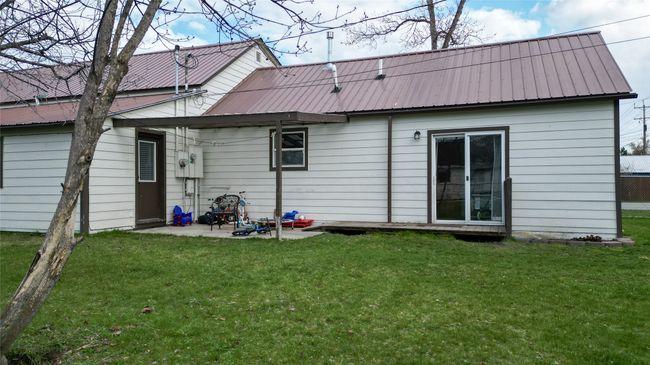 Back of house featuring a lawn, a patio, and metal roof | Image 44