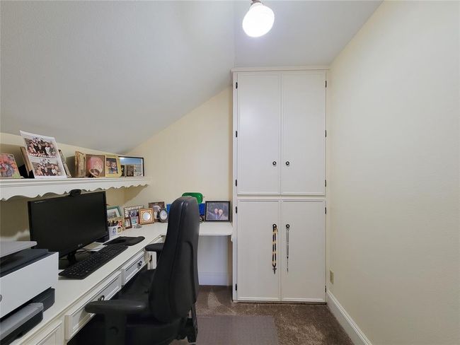 Discover a cozy study room next to the upstairs living area, featuring a built-in desk and ample cabinets. | Image 23