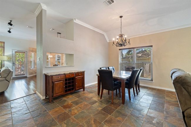 Dining area with ornamental molding, baseboards, stone tile floors, healthy amount of natural light, and lofted ceiling | Image 7