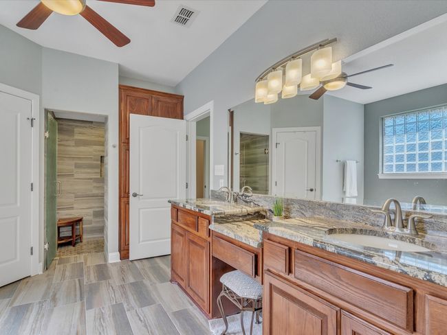 Bathroom with a ceiling fan, a stall shower, and double vanity | Image 21
