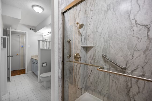 Full bath featuring a marble finish shower, vanity, tile patterned flooring, and toilet | Image 20