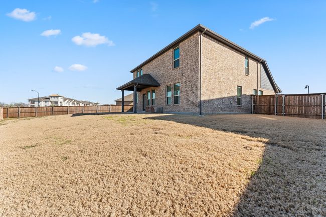 Back of house featuring brick siding, a fenced backyard, and a lawn | Image 21