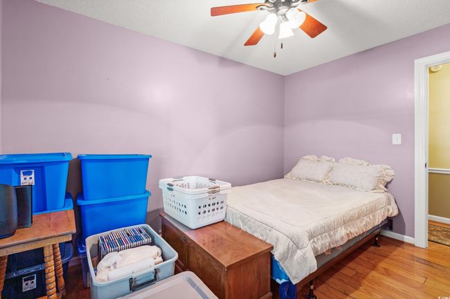 Bedroom with wood finished floors, ceiling fan, and baseboards | Image 15
