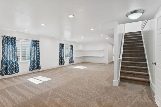 Below grade area with light colored carpet, stairs, recessed lighting, and healthy amount of natural light | Image 22