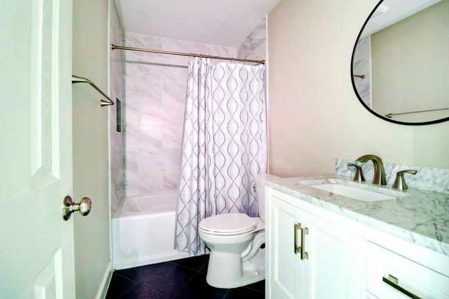 Full bathroom featuring vanity, shower / bath combo, and tile patterned floors | Image 17