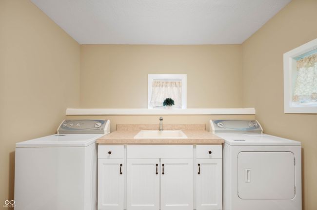 Laundry room complete with utility sink, folding table, and closet. | Image 52