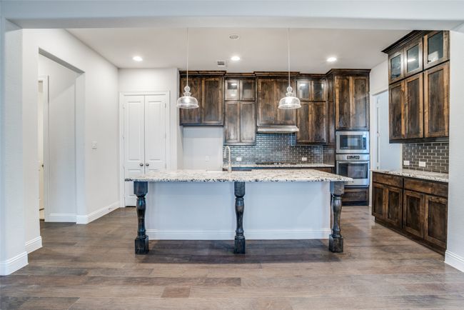 Kitchen featuring stainless steel appliances, dark brown cabinetry, decorative backsplash, and recessed lighting | Image 9