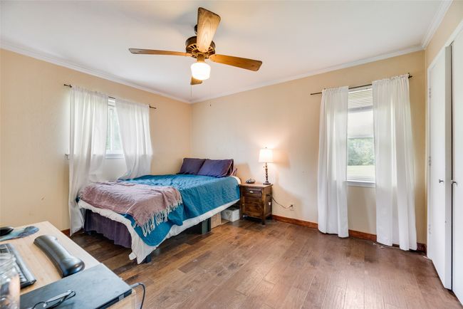 Bedroom with baseboards, multiple windows, ornamental molding, and hardwood / wood-style floors | Image 22