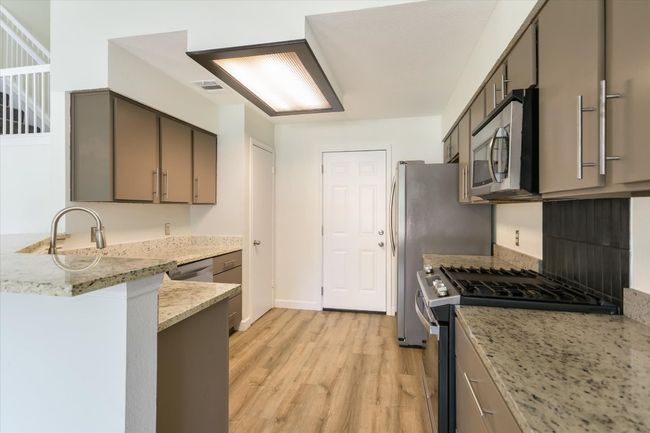 The kitchen is adorned with custom cabinets and granite counters. | Image 8