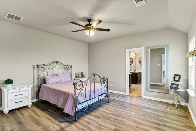 Bedroom with wood-type flooring, connected bathroom, vaulted ceiling, and ceiling fan | Image 18