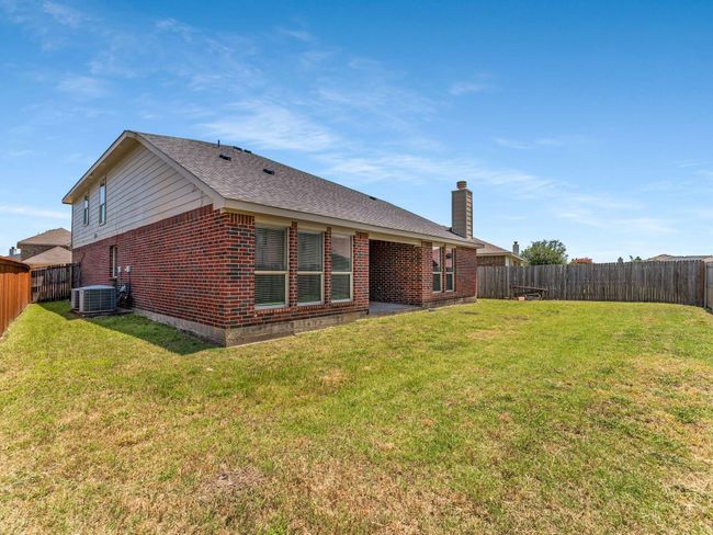 Rear view of property featuring brick siding, a fenced backyard, and a chimney | Image 37