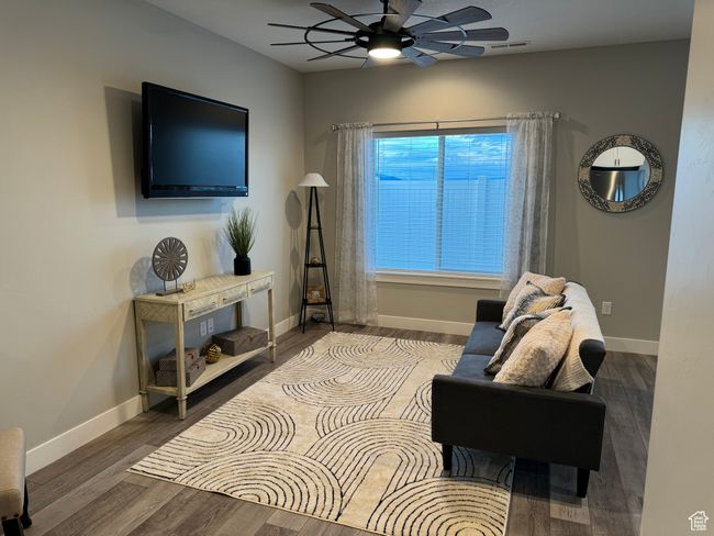 Sitting room featuring dark wood-type flooring and ceiling fan | Image 11
