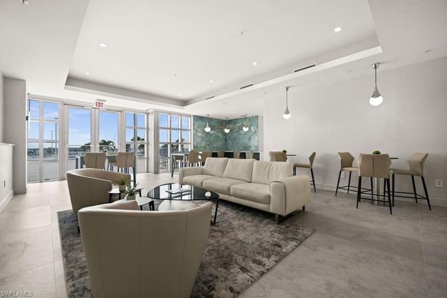 Living room with light tile patterned floors, a raised ceiling, and floor to ceiling windows | Image 32