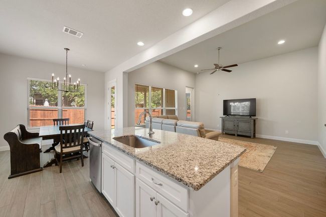 Kitchen with a sink, stainless steel dishwasher, recessed lighting, ceiling fan, and white cabinetry | Image 8