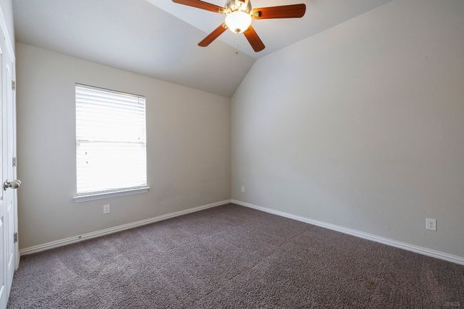 Unfurnished room with dark carpet, a ceiling fan, and vaulted ceiling | Image 19