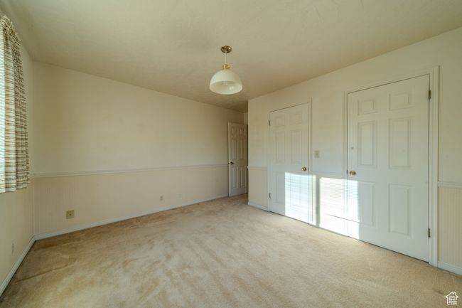 Unfurnished bedroom with baseboards, multiple windows, and carpet | Image 26