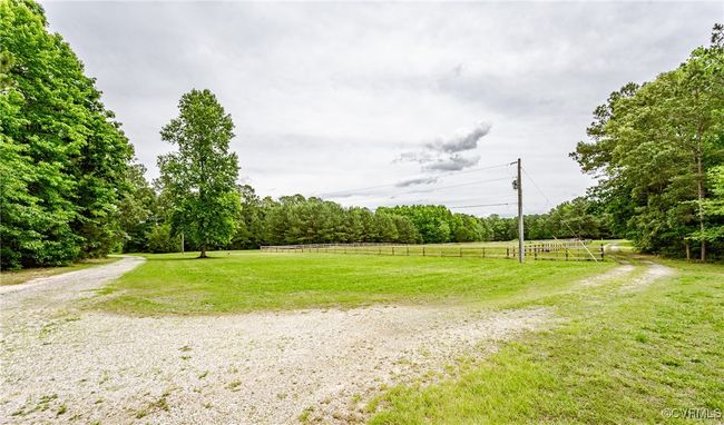 View of dirt / gravel road with a rural view and a forest view | Image 7
