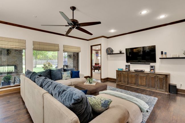 Living room with recessed lighting, dark wood finished floors, a ceiling fan, crown molding, and baseboards | Image 7