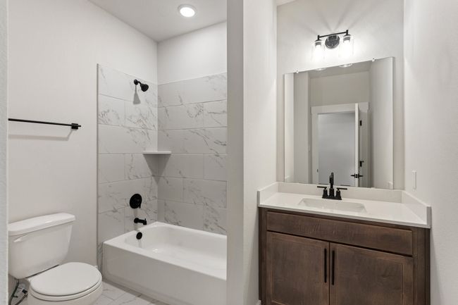 Bathroom with marble look tile flooring, vanity, and bathtub / shower combination | Image 20