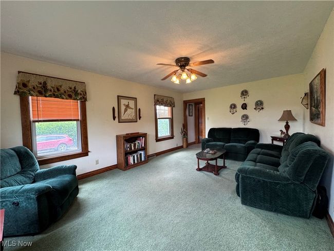 Living room with carpet flooring, ceiling fan, baseboards, and a textured ceiling | Image 23