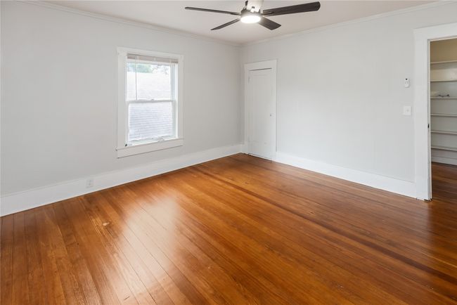 Empty room with a ceiling fan, hardwood / wood-style floors, baseboards, and ornamental molding | Image 17