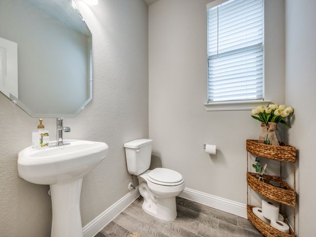 Well-appointed half bath features a classic pedestal sink and tasteful finishes. | Image 17
