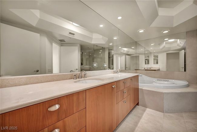 Bathroom featuring tile patterned flooring, visible vents, a sink, and a stall shower | Image 10