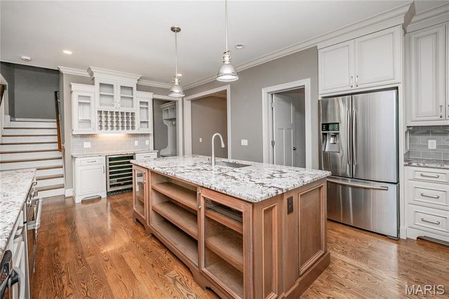 Kitchen with open shelves, backsplash, a sink, stainless steel appliances | Image 10