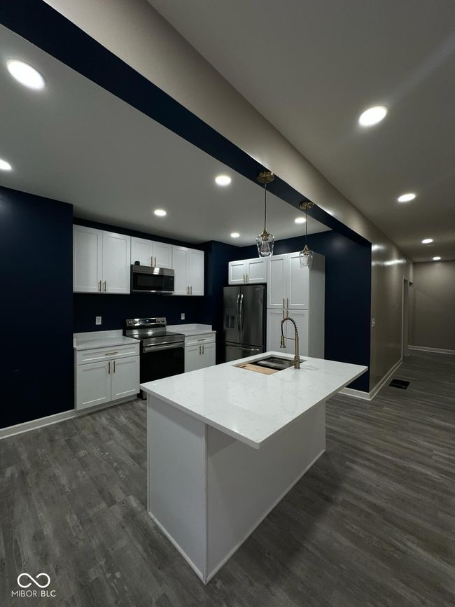 Unit 1 - Kitchen featuring stainless steel microwave, fridge with ice dispenser, electric range, dark wood-type flooring, and recessed lighting | Image 5