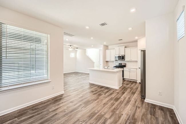Kitchen featuring stainless steel appliances, tasteful backsplash, visible vents, and open floor plan | Image 11
