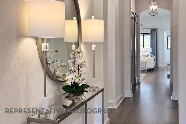 Hall featuring dark wood-type flooring, a textured wall, a barn door, and arched walkways | Image 29